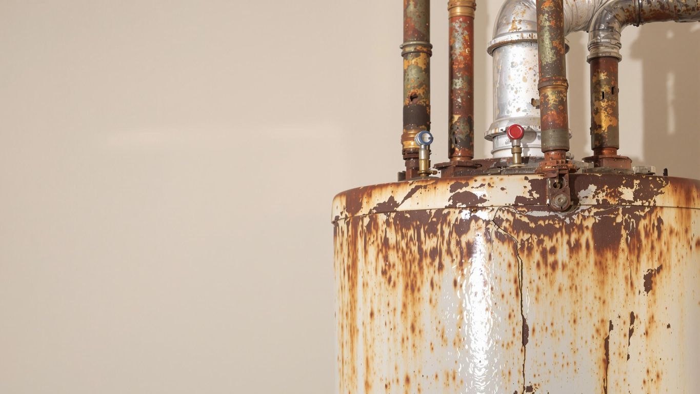 Rusty water heater with visible corrosion and wear.