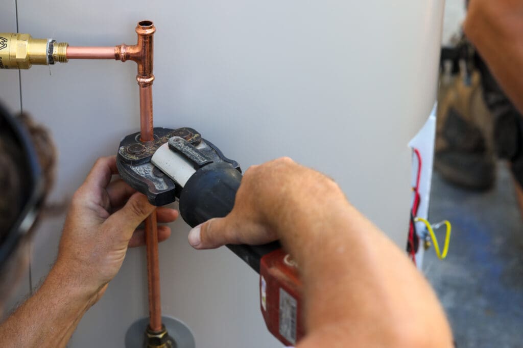 repair man fixing the water heater pipe